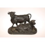 A PATINATED BRONZE GROUP OF A BULL AND COW, the bull modelled standing,