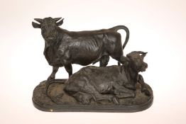 A PATINATED BRONZE GROUP OF A BULL AND COW, the bull modelled standing,