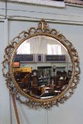 Ornate circular gilt framed bevelled wall mirror