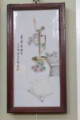 Chinese porcelain plaque painted with books and flowers by a flaming lamp,