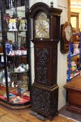 Carved oak eight day longcase clock having moon phase arched dial signed Adam Travers,