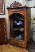 Victorian walnut and ebonised vitrine having carved crest above a glazed arched panel door with