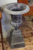 Pair cast campana style garden urns on square tapered bases,