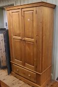 Pine wardrobe having pair panelled doors above a base drawer,