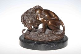 Bronze lion and snake sculpture on marble base