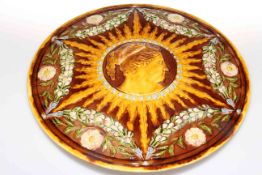 Linthorpe Pottery plaque decorated with a profile of a maiden surrounded by sunburst,