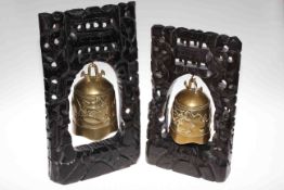 Two Chinese brass bells on carved wood stands
