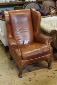 Tan leather and studded wing armchair