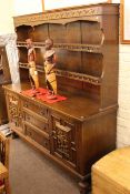 Oak shelf back dresser with armorial panelled doors,