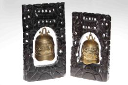 Two Chinese brass bells on carved wood stands