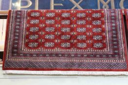 Bokhara style carpet with a red ground, 2.40m x 1.