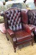 Ox blood buttoned leather wing armchair on cabriole legs