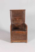 AN OAK AND PINE ENCLOSED CHAIR, with tapering back and boarded seat with panelled sides. 100cm high.