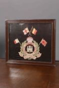 A REGIMENTAL EMBROIDERED TRAPUNTO, THE SUFFOLK REGIMENT, in a faux rosewood moulded frame.