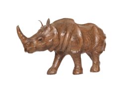 A LEATHER-COVERED WOODEN-FRAMED MODEL OF A RHINOCEROS, 20th century, modelled walking,