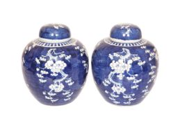 A PAIR OF CHINESE BLUE AND WHITE PORCELAIN COVERED JARS, decorated with prunus,