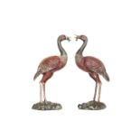 A PAIR OF PAINTED AND CAST METAL MODELS OF CRANES, each modelled standing on a naturalistic base.