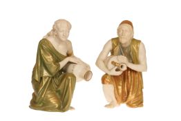 A PAIR OF WORCESTER SHOT ENAMELS FIGURES OF WATER CARRIERS, each wearing Middle Eastern dress,
