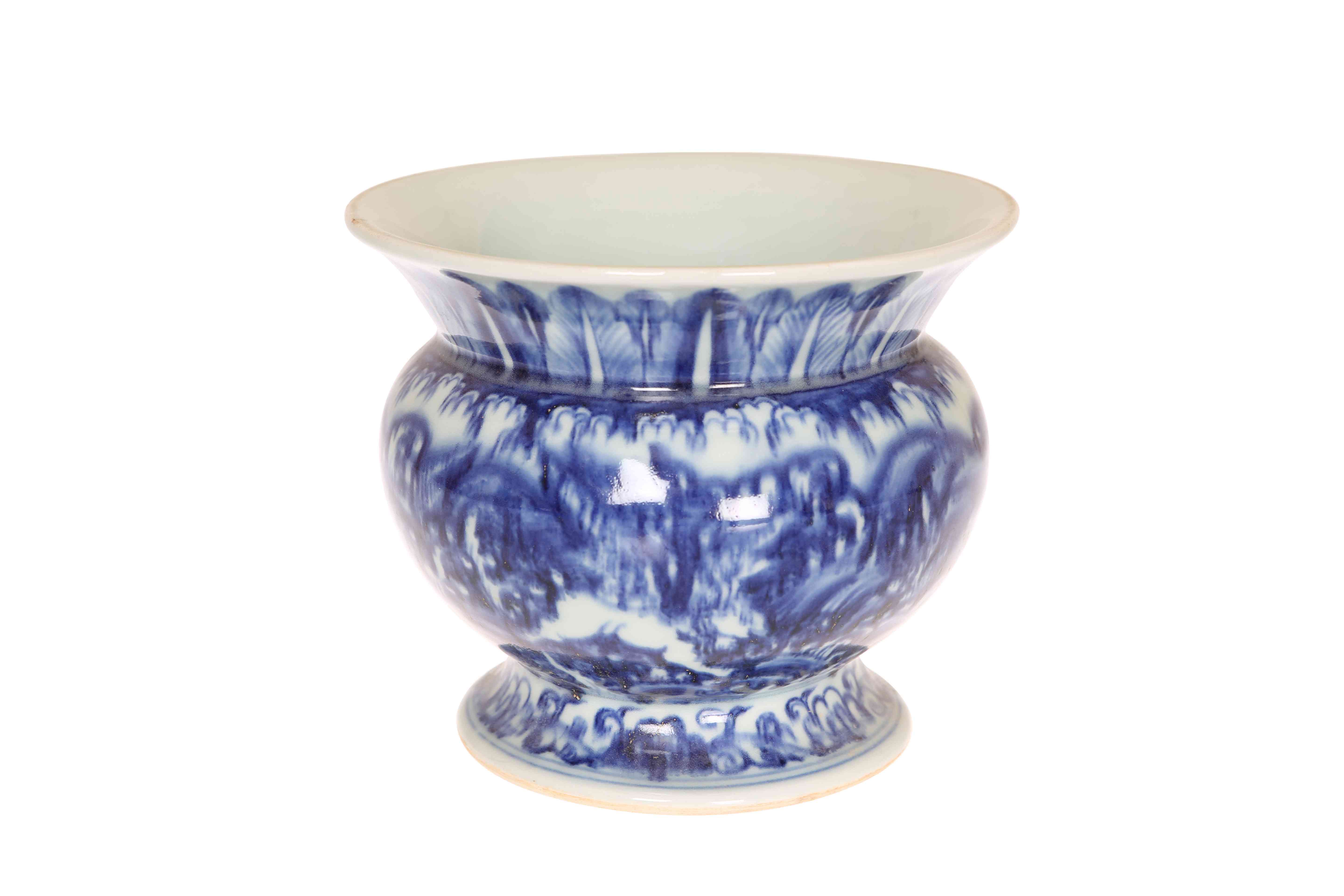 A CHINESE BLUE AND WHITE SPITTOON, the everted collar with stiff leaf decoration.