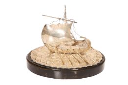 A SILVER MODEL OF A GREEK BOAT, on a naturalistic "sea" base, stamped 900,