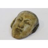 A CHINESE CARVED SOAPSTONE MASK OF THE BUDDHA, mounted in a hardwood stand.