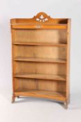 AN ARTS AND CRAFTS OAK OPEN BOOKCASE, the gallery with foliate cut-out, raised on trestle ends,