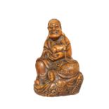 A CHINESE SOAPSTONE FIGURE OF A SEATED LOHAN, carved seated and holding a Buddhistic lion pup.