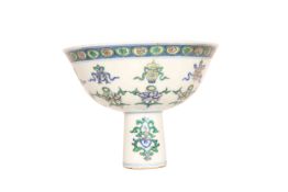 A CHINESE PORCELAIN STEM CUP, painted with objects and sprigs of foliage,