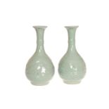 A PAIR OF CHINESE CELADON BOTTLE VASES, each with moulded body, (a/f). 28.