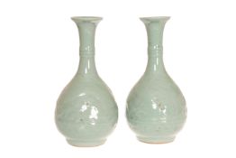 A PAIR OF CHINESE CELADON BOTTLE VASES, each with moulded body, (a/f). 28.