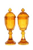 A PAIR OF CONTINENTAL LARGE AMBER GLASS JARS AND COVERS, late 19th century,