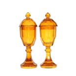 A PAIR OF CONTINENTAL LARGE AMBER GLASS JARS AND COVERS, late 19th century,