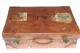 Vintage leather suitcase with brass fittings and luggage labels for Grand Hotel,
