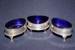 Set of three Georgian silver oval salts with blue glass liners