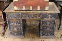 Carved oak twin pedestal desk with lion mask handles and leather inset top,