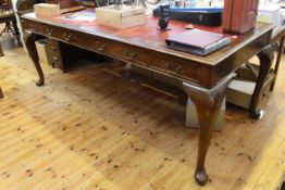 Early 20th Century mahogany plan table with red leather top, raised on cabriole legs,