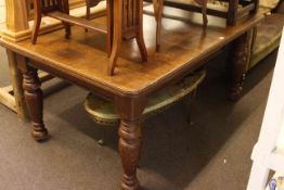 Oak extending dining table raised on turned legs with one leaf