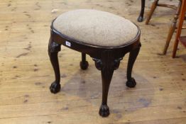 Oval mahogany stool raised on cabriole legs to paw feet