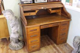 Oak roll top desk with S shaped tambour front concealing drawers and pigeon holes,