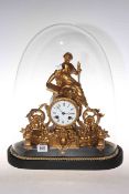 Ornate gilded metal mantel clock with figural and swag decoration under glass dome