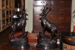 Impressive pair of bronze stags standing on rocky outcrops mounted on marble plinths,