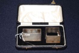 Cased pair of Art Deco silver engine turned square and rectangular napkin rings,