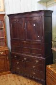 Georgian oak press having two arched panel doors above a fall front with six drawers below on