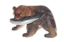 Carved wood bear with salmon in jaws