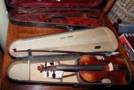 Two cased violins and bows