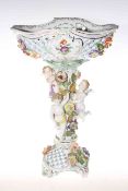 Dresden porcelain cherub centre piece, having pierced basket on naturalist column,
