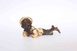 A COLD PAINTED BRONZE OF A BOY, modelled laid on his front holding a pipe, bears B in a vase mark,