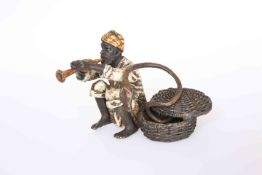 A COLD PAINTED BRONZE OF A SNAKE CHARMER, sat beside a basket with an adder coiled around him,