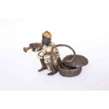 A COLD PAINTED BRONZE OF A SNAKE CHARMER, sat beside a basket with an adder coiled around him,