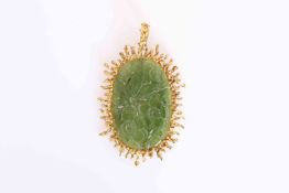 A CHINESE CARVED JADE PENDANT, the oval jade plaque carved with flowerheads and leaves,